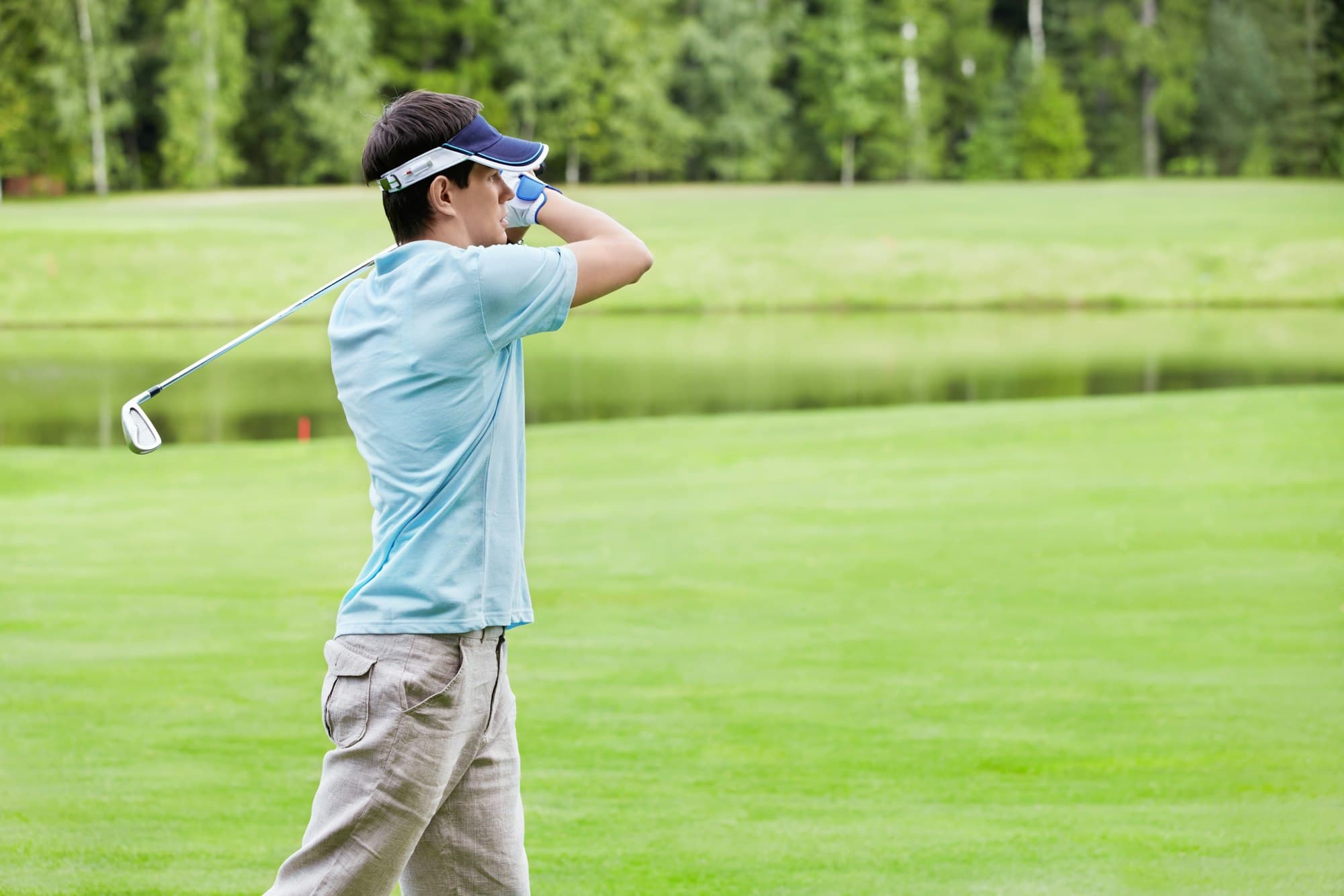 A golfer finishing a swing on the fairway.